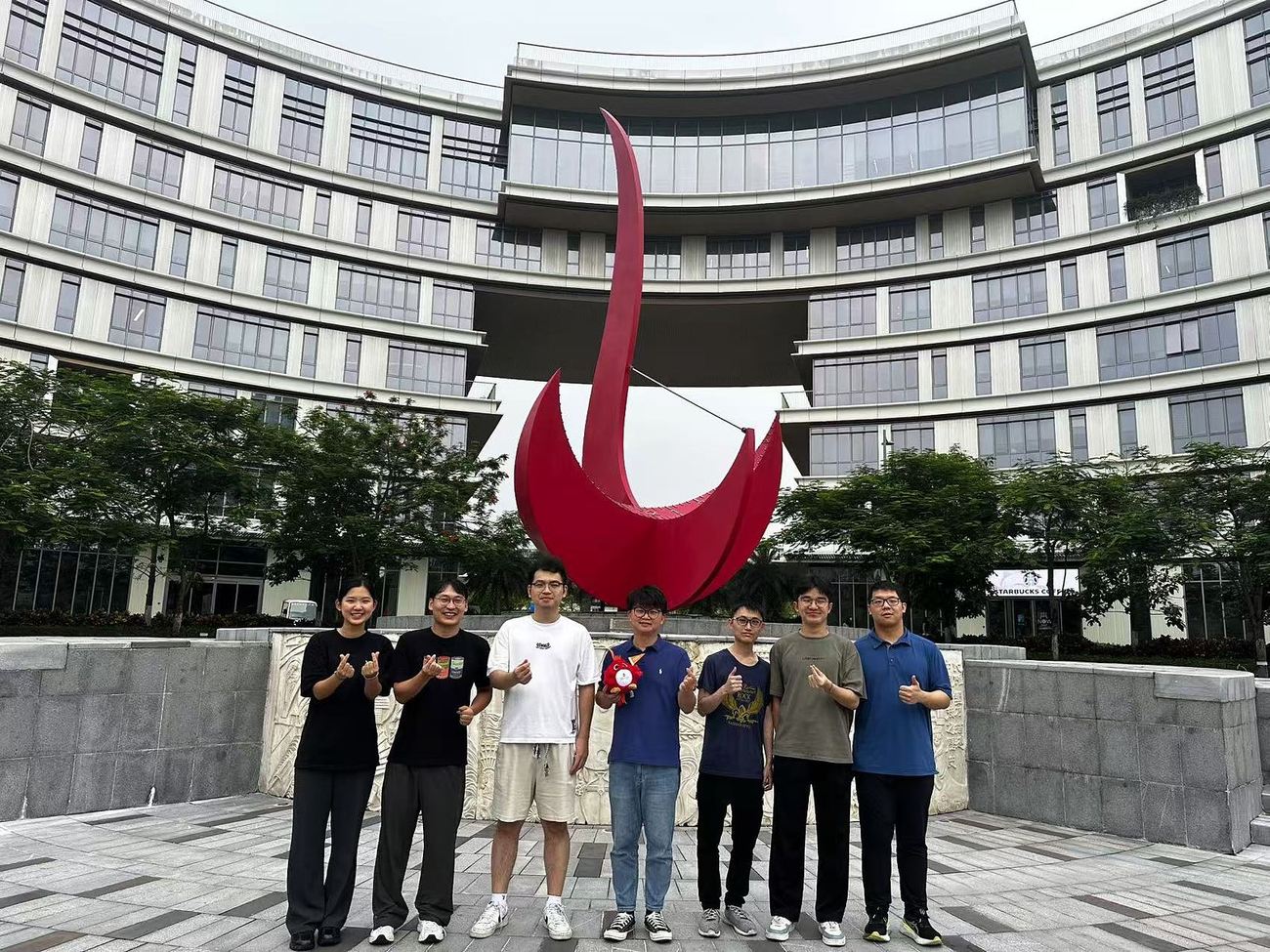 The group in front of the Red Bird sculpture on campus